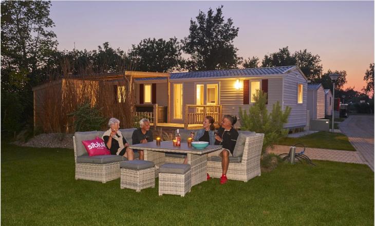 Familie op het terras van hun chalet op Vakantiepark de Oase in Renesse